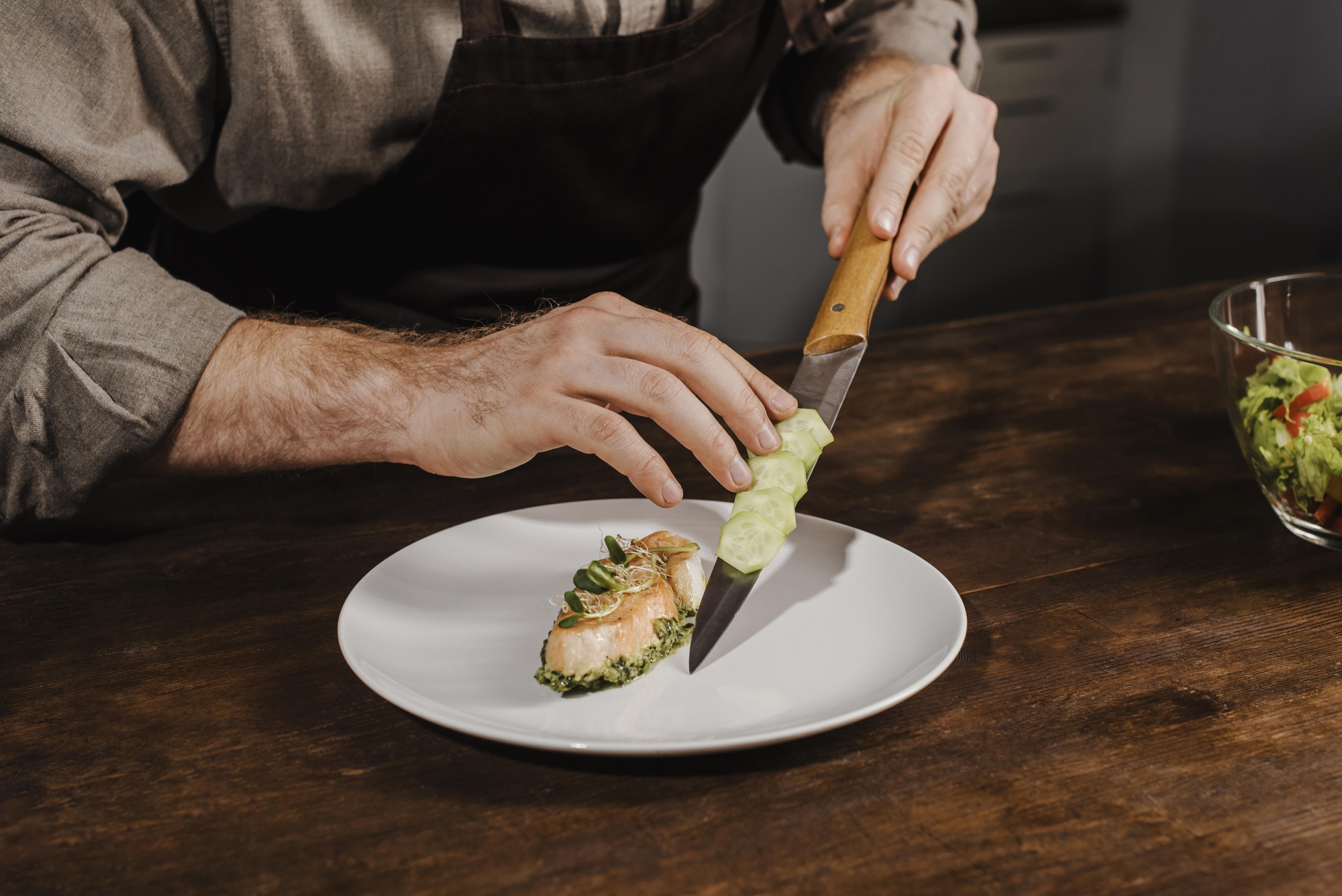 Instructor arranging plated dish on wooden table